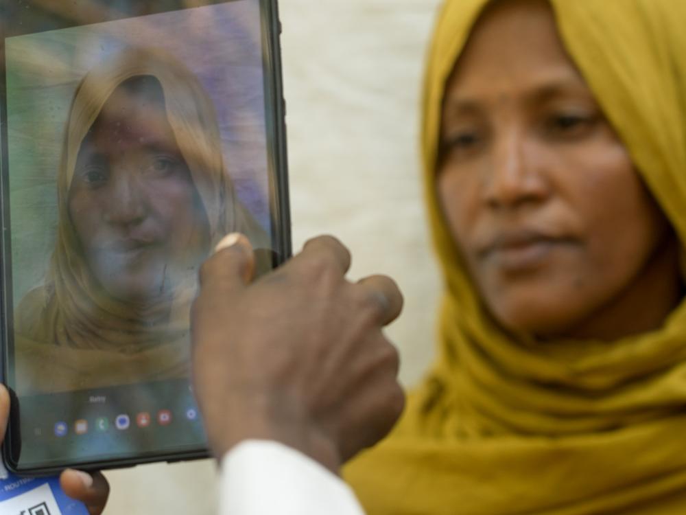 <em>Fatouma Zahara Hasan, a widow with a large family from the town of Chifera, has her photograph taken on a tablet as part of a vast registration drive to ensure that food aid funded by the United States in parts of Ethiopia is only provided to recipients that qualify.  </em>