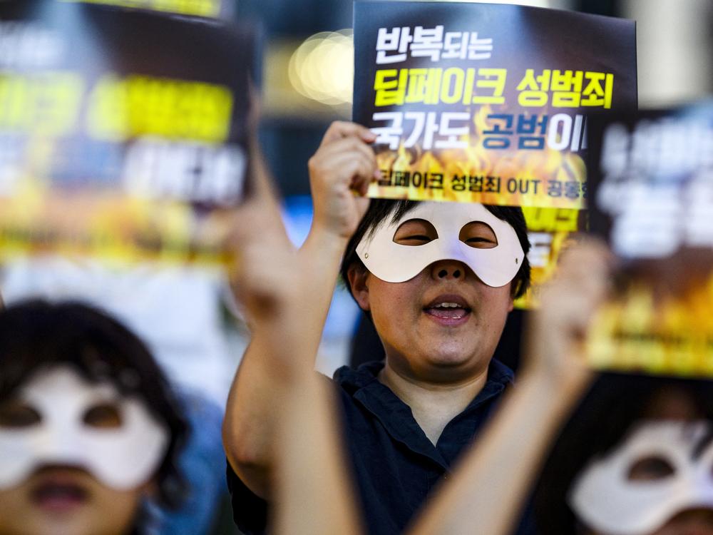 Activists wearing eye masks hold posters reading 