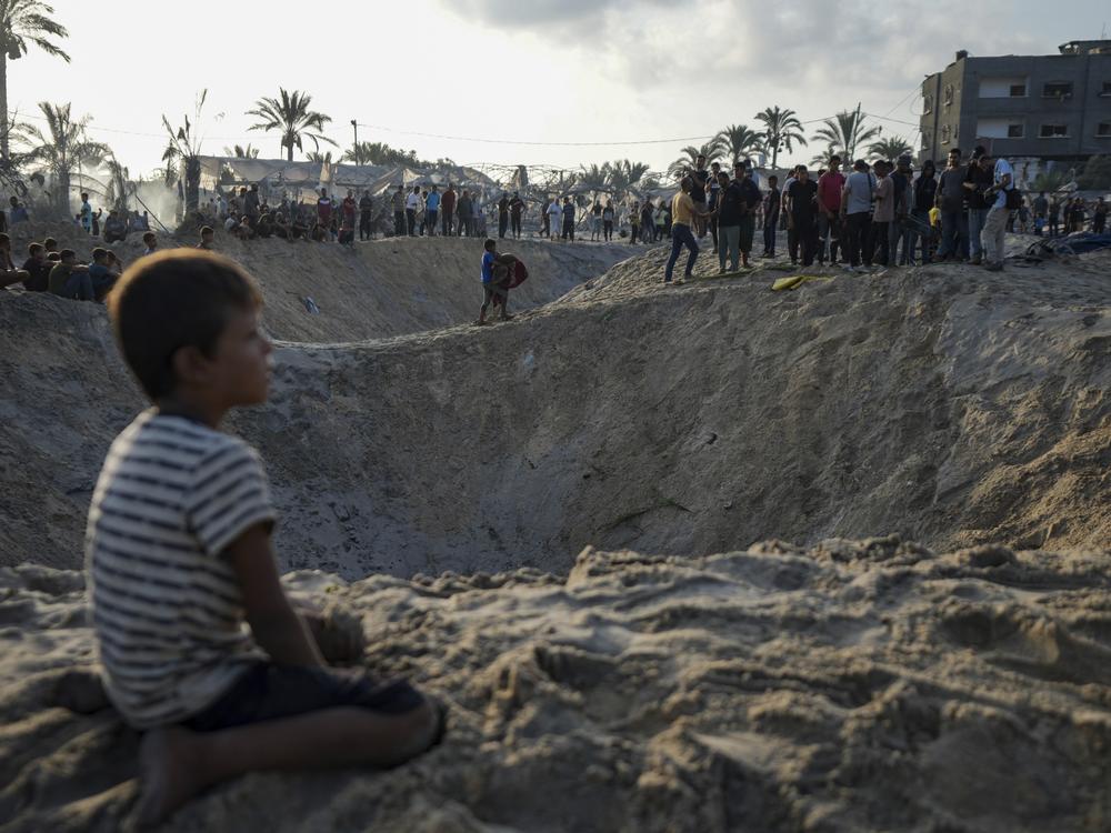 Palestinians look at the destruction after an Israeli airstrike on a crowded tent camp housing Palestinians displaced by the war in Muwasi, Gaza Strip, Tuesday, Sept. 10, 2024.