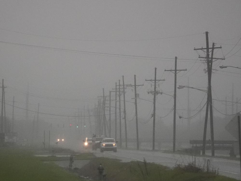 Cars drive through rain bands along Peter Rd., just outside New Orleans, ahead of Hurricane Francine, in Harvey, La., on Tuesday.