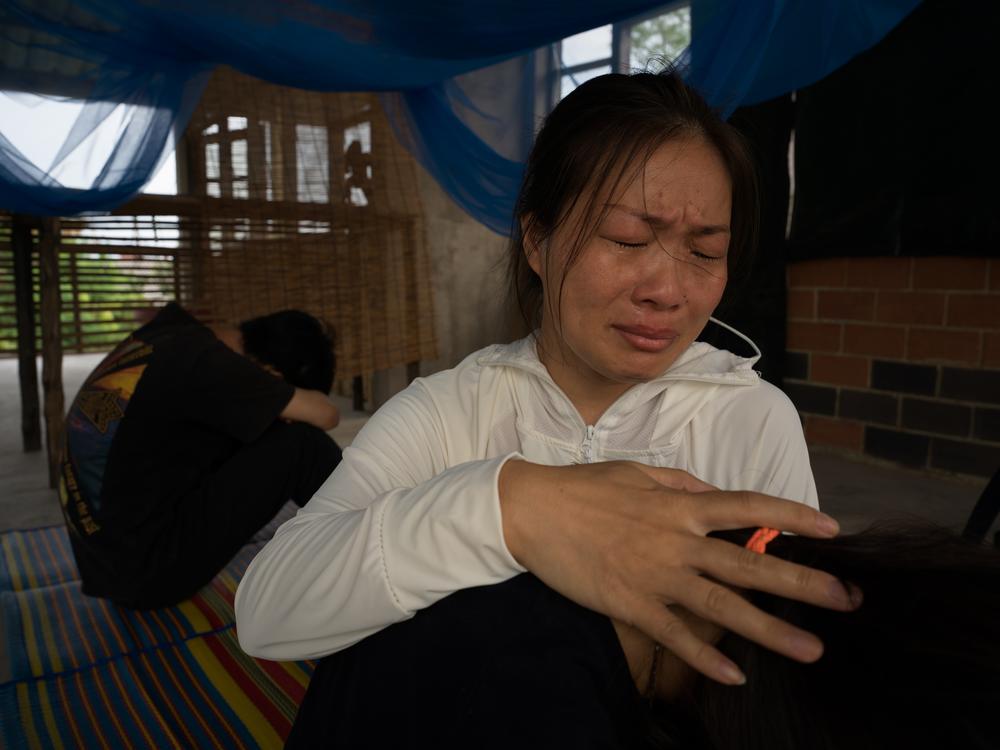 刘风岭在曼谷安慰她的女儿和儿子，此前她在拘留所里度过了四个月。