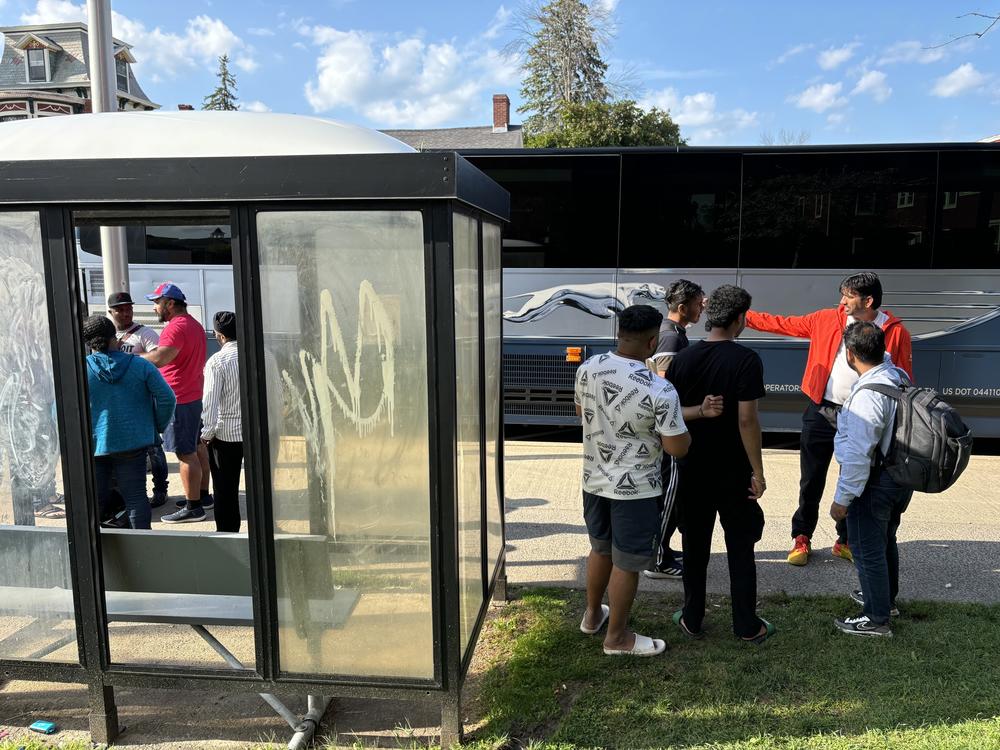 A group of Indian and Haitian immigrants arrive at a bus stop in Plattsburgh, N.Y. on a Saturday afternoon in August. The migrants were received by Indian drivers who take them to New York City for a fee.