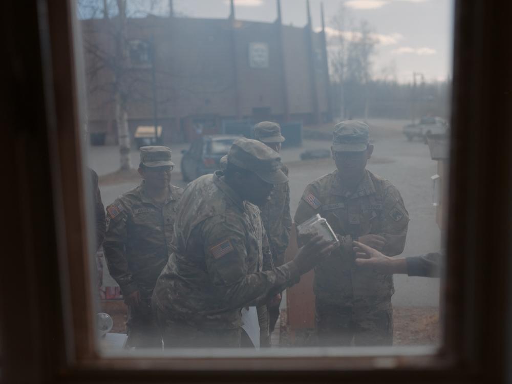 Soldiers from the 11th Airborne Division examine a jar of smoked salmon during a class at a local folk school in Fairbanks. These community outings are designed to help young soldiers build connections with their peers and their cultural surroundings in Alaska.<br />
