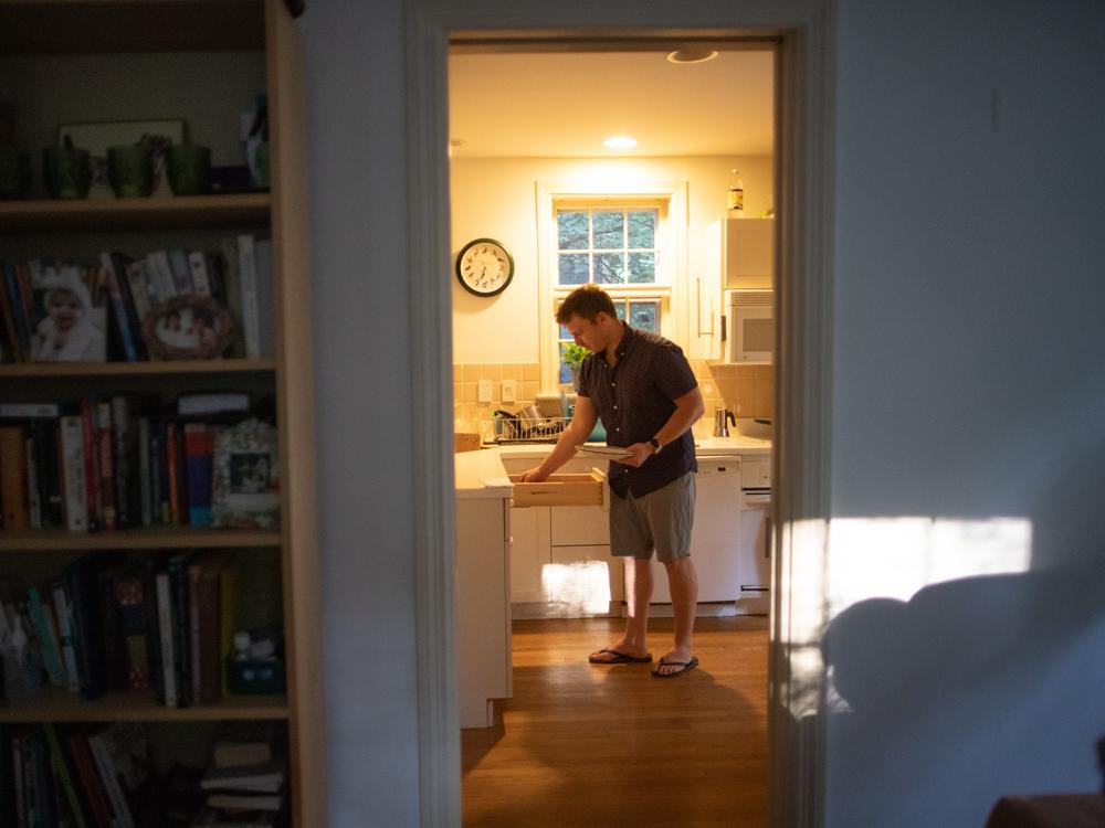  Gerhard du Plessis grabs a dinner plate while preparing to eat the Thai food he ordered for delivery. 
