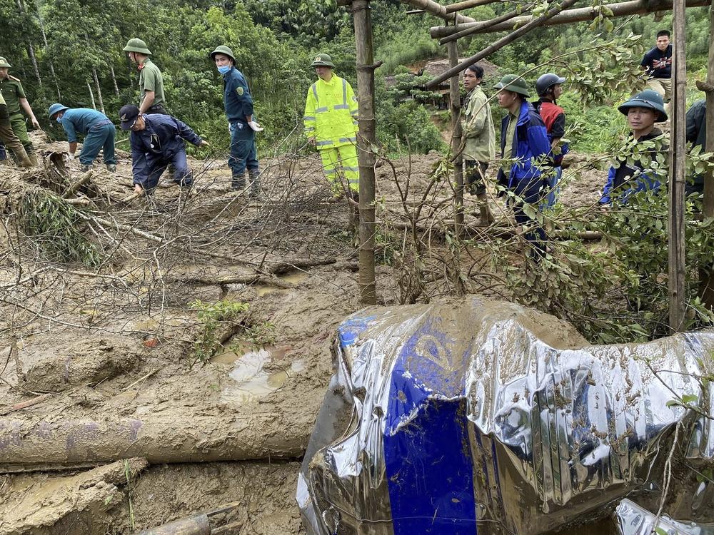 Rescue workers clear mud and debris brought down by a flood in Lang Nu hamlet in Vietnam's Lao Cai province on Tuesday.