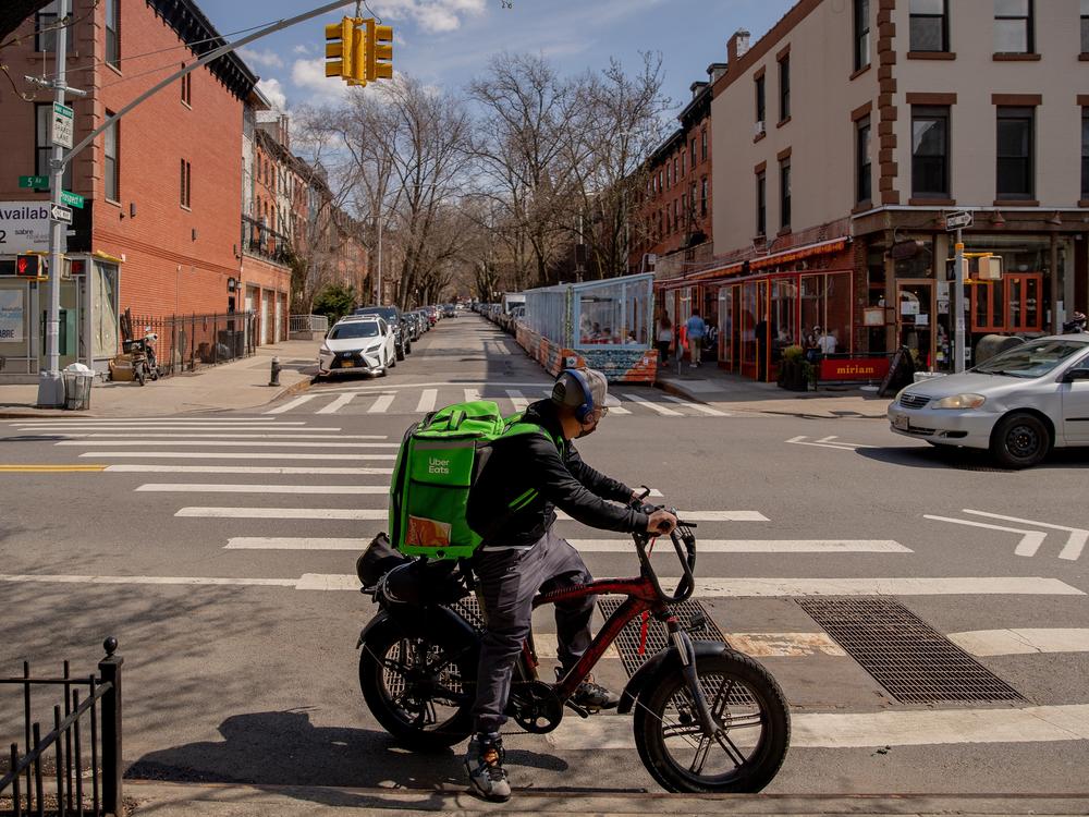 An Uber Eats delivery courier rides an electric bicycle through the Park Slope neighborhood of the Brooklyn borough of New York.