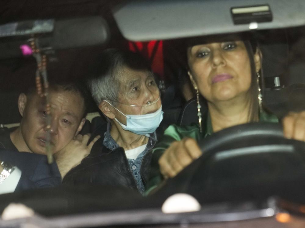 Peru's former President Alberto Fujimori (center) is driven out of prison by one of his lawyers, accompanied by his son Kenji (left) after his release in Callao, Peru, on Dec. 6, 2023. 