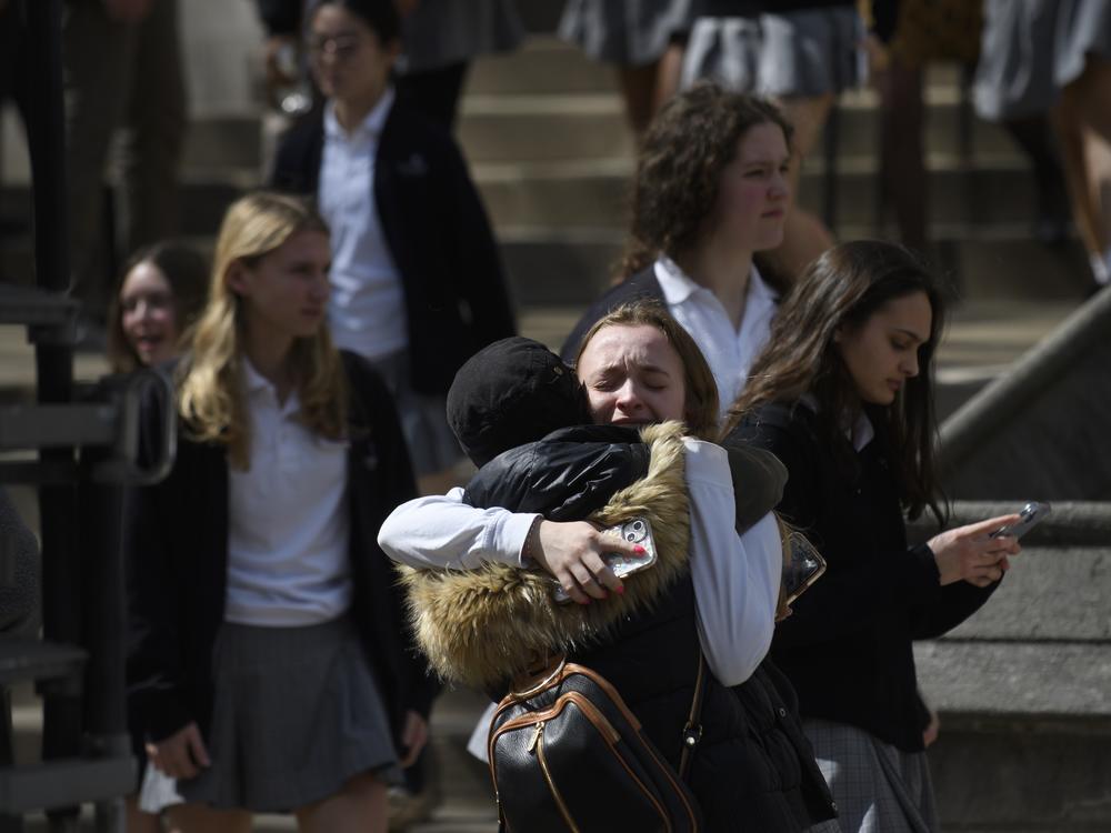 A student from Oakland Catholic High School receives comfort following the evacuation of the school after a call of an active shooter on March 29, 2023 in Pittsburgh, Pennsylvania. Many schools, including Oakland Catholic and Pittsburgh Central Catholic, were targeted as part of what authorities are calling 