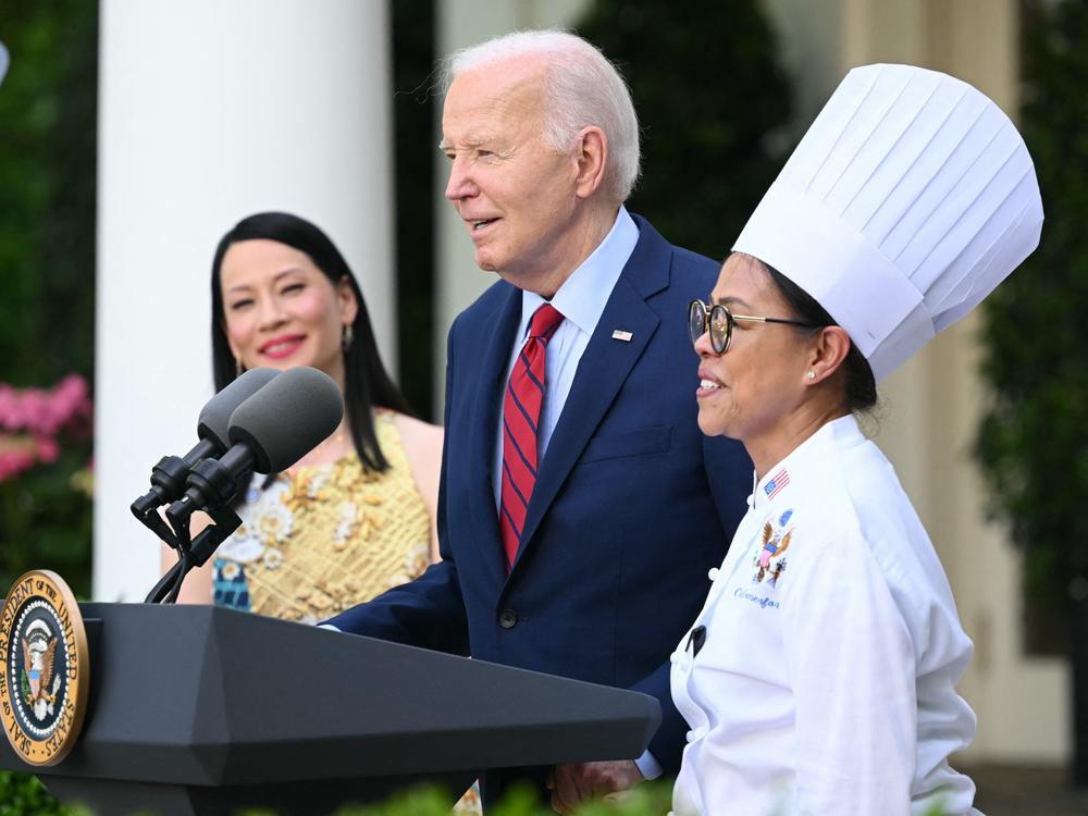 President Biden welcomes then White House executive chef Cristeta Comerford to the podium during a reception celebrating Asian American, Native Hawaiian and Pacific Islander Heritage Month in May.