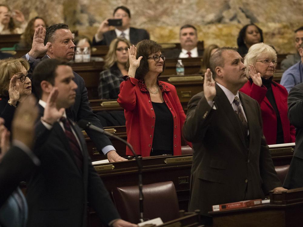 Patricia Poprik (center), who is serving as a repeat presidential elector for Trump, takes an oath with other 2016 Republican electors at the Pennsylvania state Capitol in Harrisburg, Pa.