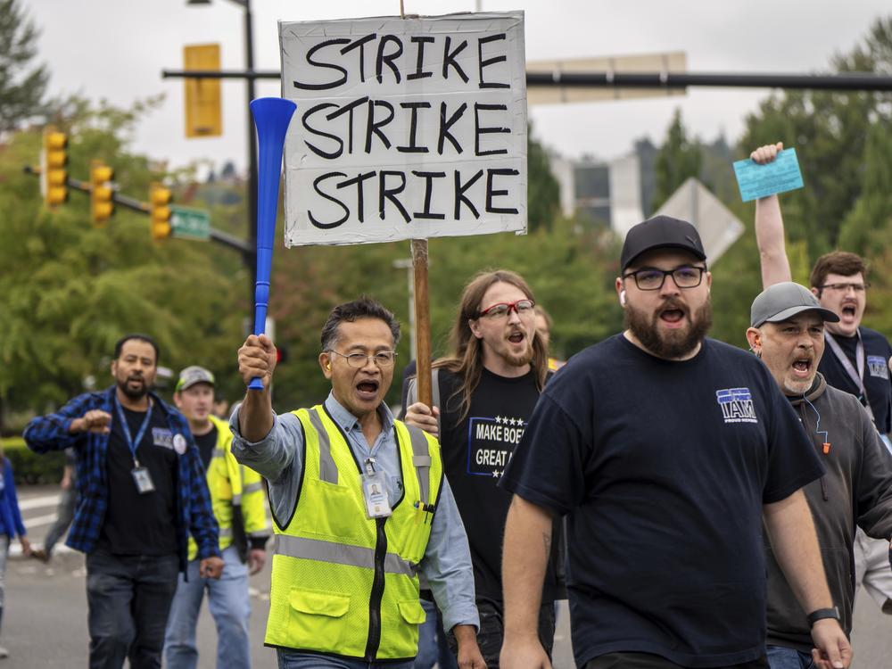 Members of the International Aerospace Machinists union march toward the union's hall Thursday to vote on a contract offer with airplane maker Boeing in Renton, Wash. Workers overwhelmingly rejected the contract and 96% voted to authorize a strike.