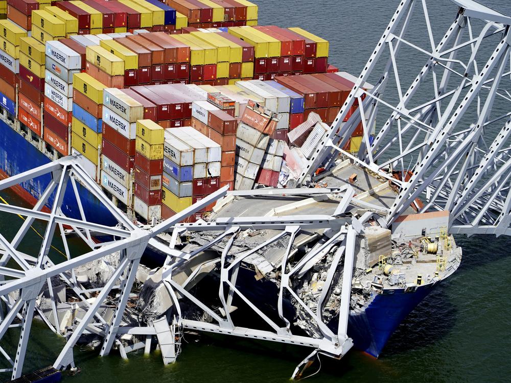 In this aerial image released by the Maryland National Guard, the cargo ship Dali is stuck under part of the structure of the Francis Scott Key Bridge after the ship hit the bridge, March 26, 2024, in Baltimore. 