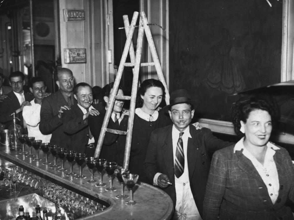 circa 1930: Members of Friday The Thirteenth Club walk under a ladder in single file at a meeting on the outskirts of Paris. The club meets every Friday 13th to do everything that superstitious people traditionally avoid. 