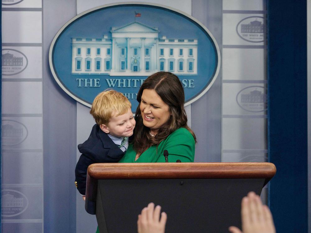 Sarah Huckabee Sanders plays with one of her sons in the briefing room on 