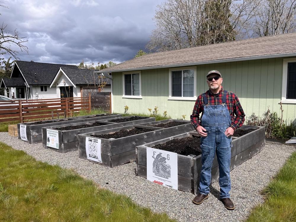  David Thompson stands in front of six raised garden beds at Triple Earl Farms, a Food Independence Garden in a South Tacoma neighborhood maintained by Thompson's organization Food is Free Washington on April 26, 2024.