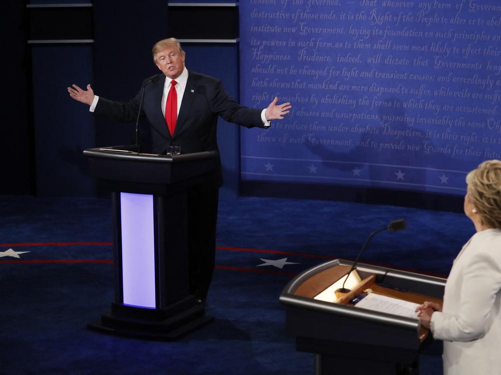 Republican presidential nominee Donald Trump speaks as Democratic presidential nominee Hillary Clinton (R) looks on during the final presidential debate at the Thomas & Mack Center on the campus of the University of Las Vegas in Las Vegas on Oct. 19, 2016.