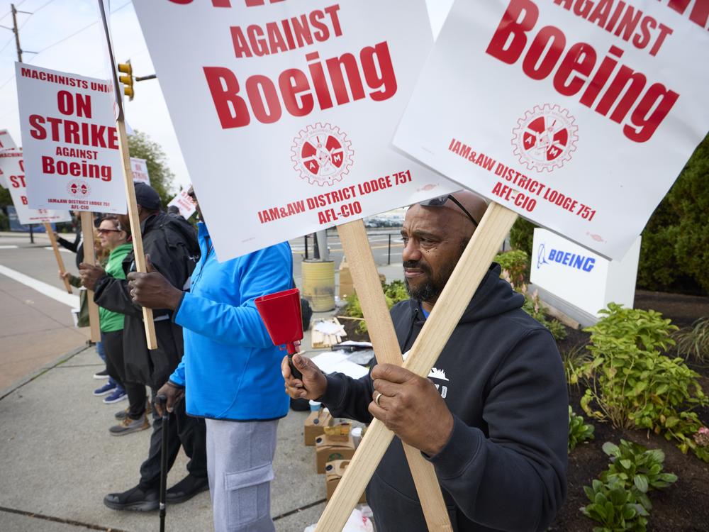 Boeing workers hold signs on the picket line at the Renton assembly plant on Friday in Renton, Wash.