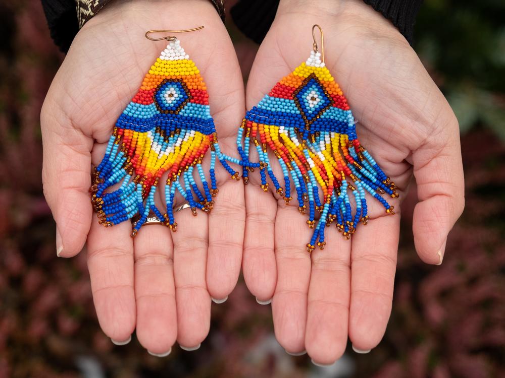 <em>Kâlánguak is getting in touch with her Inuit roots through bead artistry. In her hands, she holds a pair of earrings that represent her two fathers — her adoptive father and her biological father.</em>