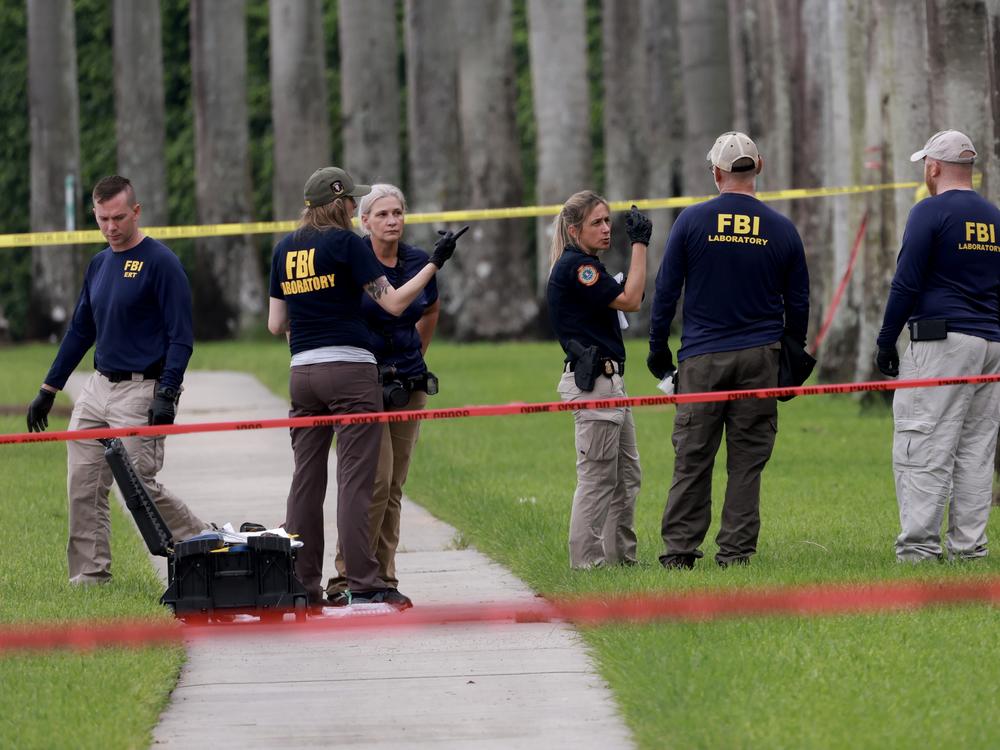 Law enforcement personnel continue to investigate the area Tuesday where the Secret Service discovered a would-be assassin of former President Donald Trump at the Trump International Golf Club on Sunday in West Palm Beach, Fla.