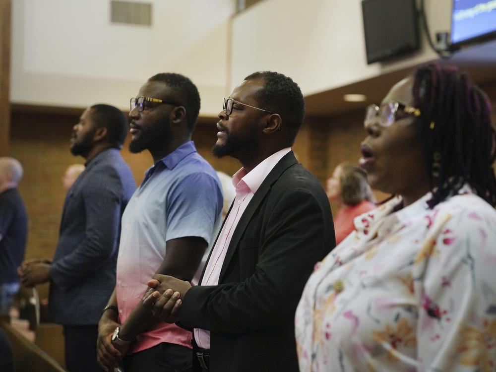 Members of the Haitian community in Springfield, Ohio, from left, Lindsay Aime, James Fleurijean, Viles Dorsainvil, and Rose-Thamar Joseph, stand for worship at Central Christian Church, on Sunday, Sept. 15, 2024. 