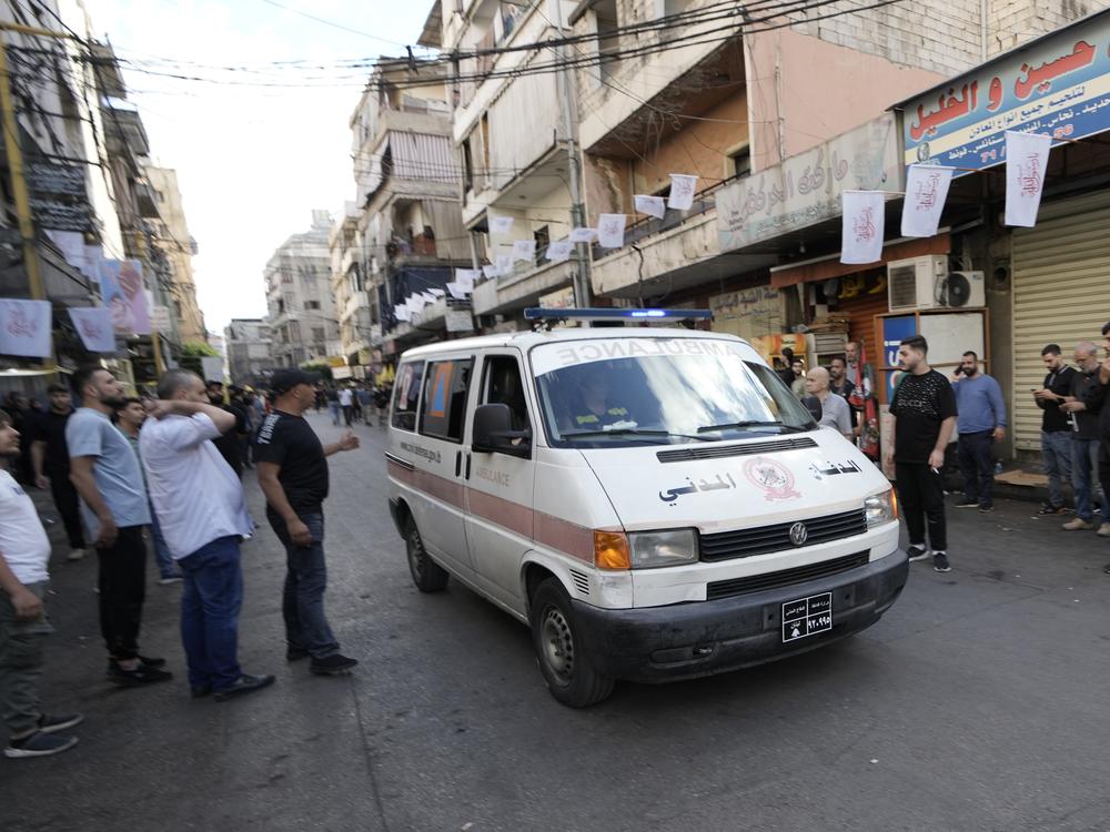 An ambulance believed to be carrying wounded people — after multiple explosions were heard during the funeral of four Hezbollah fighters who were killed Tuesday after their pagers exploded — drives down a street in a southern suburb of Beirut on Wednesday.