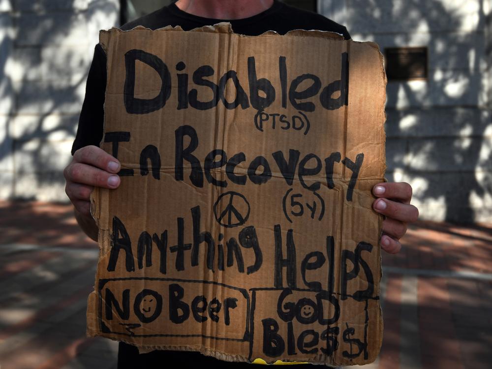 Drug use remains dangerous and debilitating for many people in the U.S. A person in addiction pleaded for help on a street corner in Burlington, Vermont. 