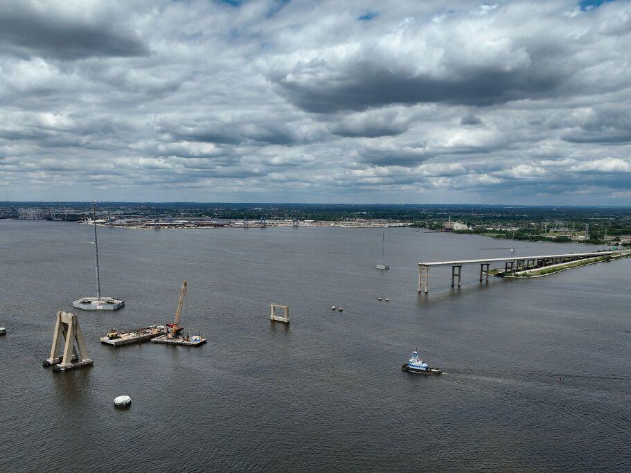 A tug boat travels toward the Port of Baltimore as salvage crews continue to clean up wreckage from the collapse of the Francis Scott Key Bridge in the Patapsco River on June 11 in Baltimore. The city's Fort McHenry Federal Channel opened for shipping traffic months after the cargo ship Dali collided with the bridge, causing it to collapse.
