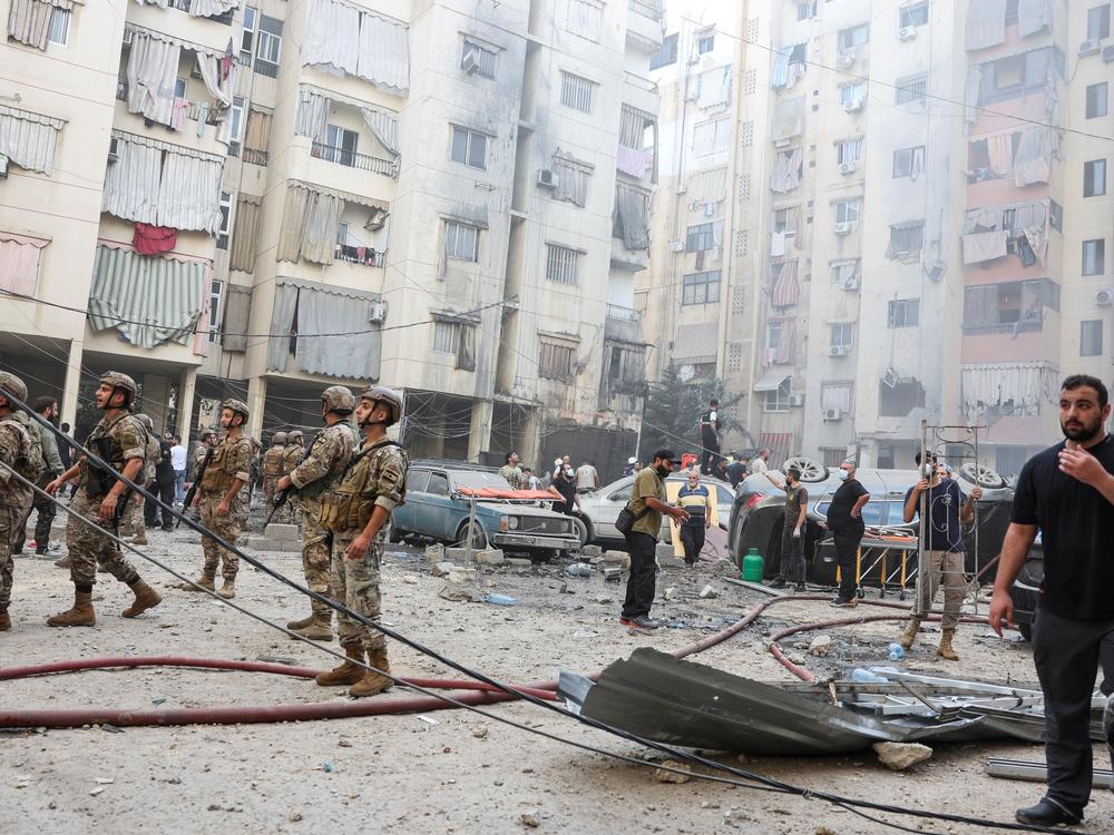 People and members of the military inspect the site of an Israeli strike in the southern suburbs of Beirut, Lebanon, on Friday.