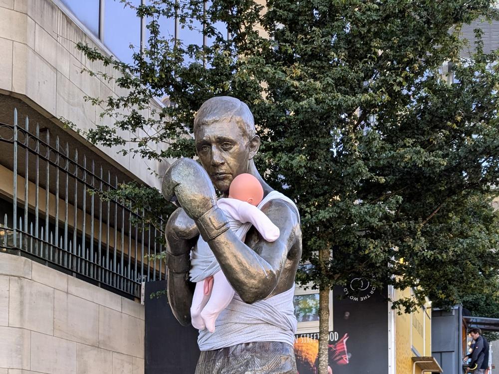 A statue of boxer Ken Buchanan in Edinburgh, Scotland. Buchanan is adorned with a baby doll wrapped around him as part of a campaign to raise awareness about paternity leave.