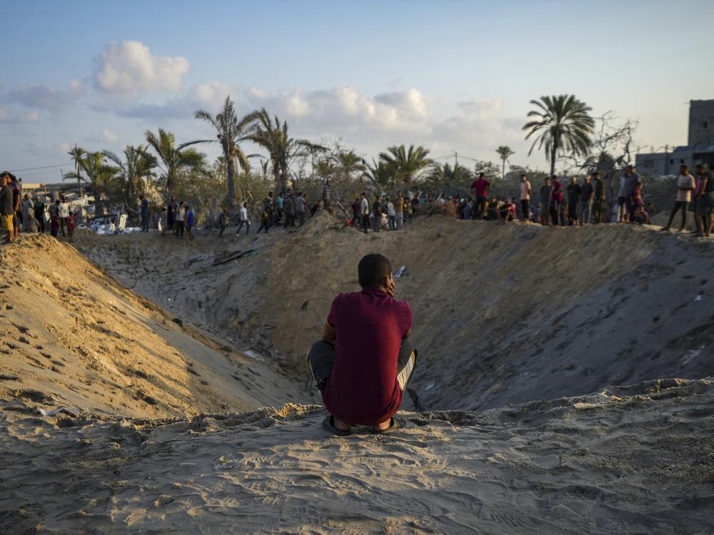 Palestinians look at the destruction caused by an Israeli airstrike on a crowded tent camp housing displaced Palestinians in Muwasi, Gaza Strip, on Sept. 10. The current round of Israeli-Hamas fighting has been ongoing for nearly a year. The larger Israeli-Palestinian conflict dates back generations. 