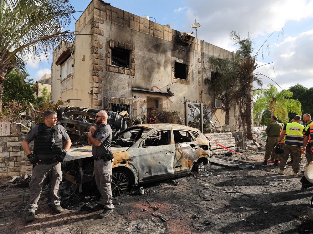 First responders and Israeli security forces gather amid debris and charred vehicles in Kiryat Bialik in the Haifa district of Israel, following a strike by Lebanon's Hezbollah on Sunday.