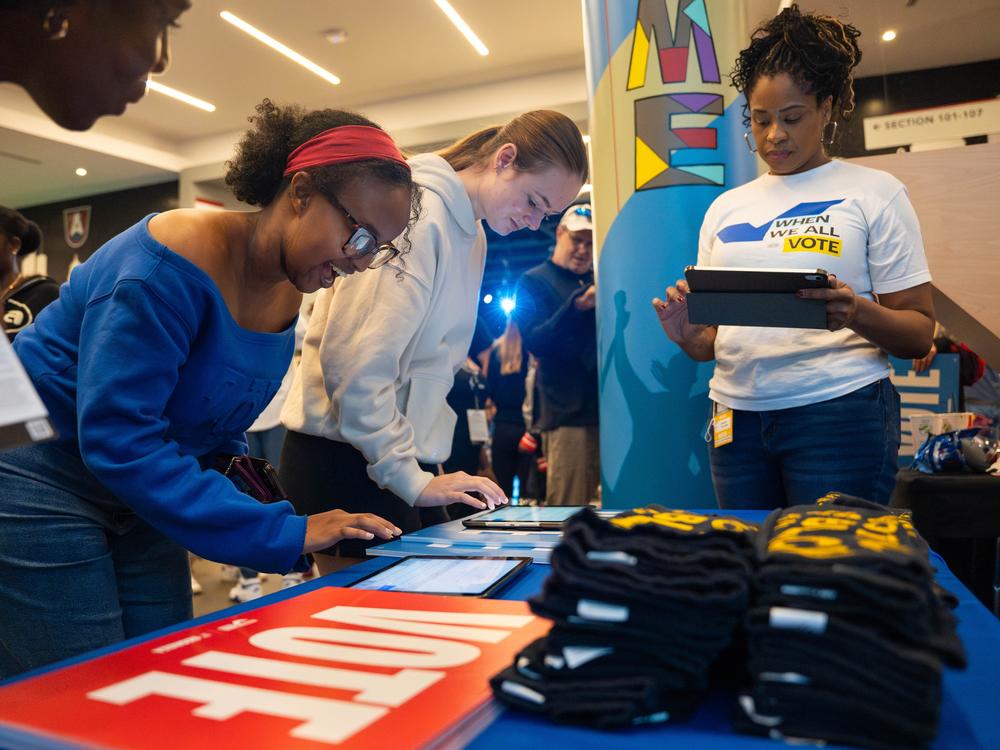 Game attendees check their voter registration status at the When We All Vote booth inside the Gateway Center Arena during an Atlanta Dream home game on Tuesday, Sept. 17, 2024.