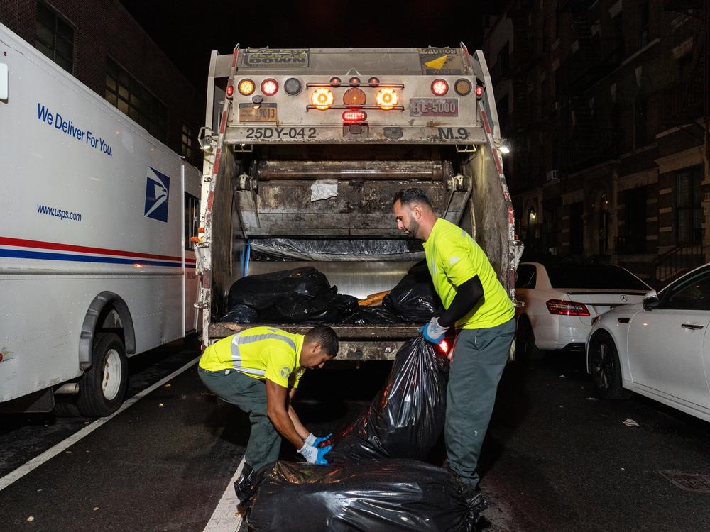  Sanitation workers collect trash in Harlem. 