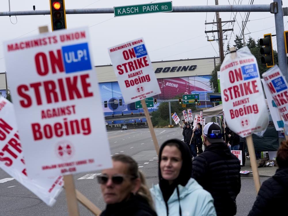 Boeing workers wave picket signs as they strike after union members voted to reject a contract offer, Sunday, Sept. 15, 2024, near the company's factory in Everett, Wash.