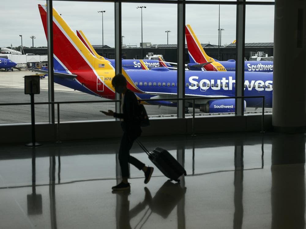 A traveler walks past a Southwest Airlines airplane as it taxis at Baltimore Washington International Thurgood Marshall Airport on October 11, 2021 in Baltimore.