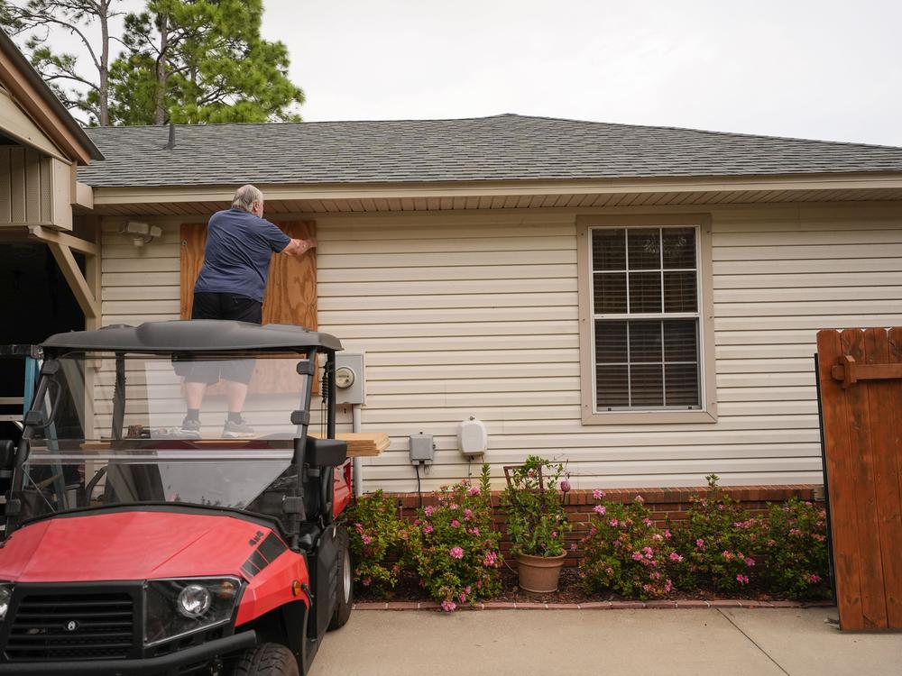Dave McCurley boards up the windows of his home in expectation of Hurricane Helene, in Ochlockonee Bay, Fla., on Wednesday, Sept. 25.