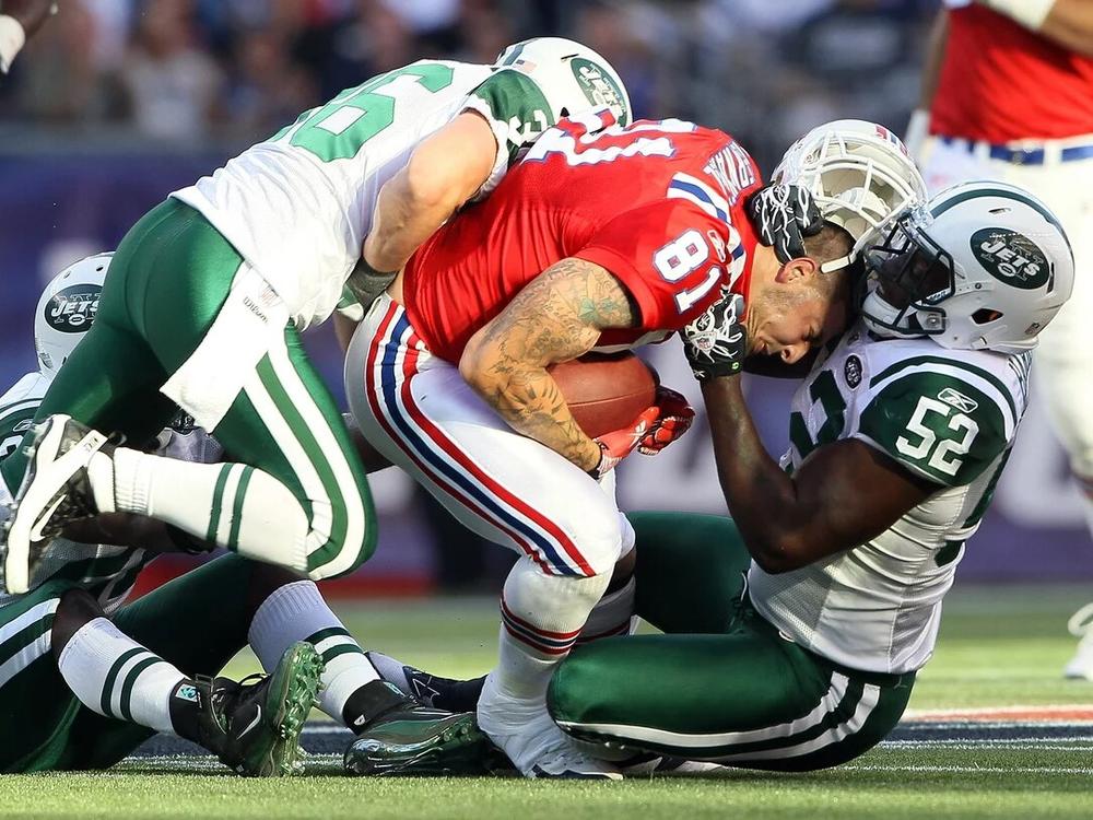 Aaron Hernandez (81), of the New England Patriots, lost his helmet during this play against the New York Jets in 2011. Hernandez died by suicide in 2017, and researchers found that he had had one of the most severe cases of CTE ever seen in someone his age.