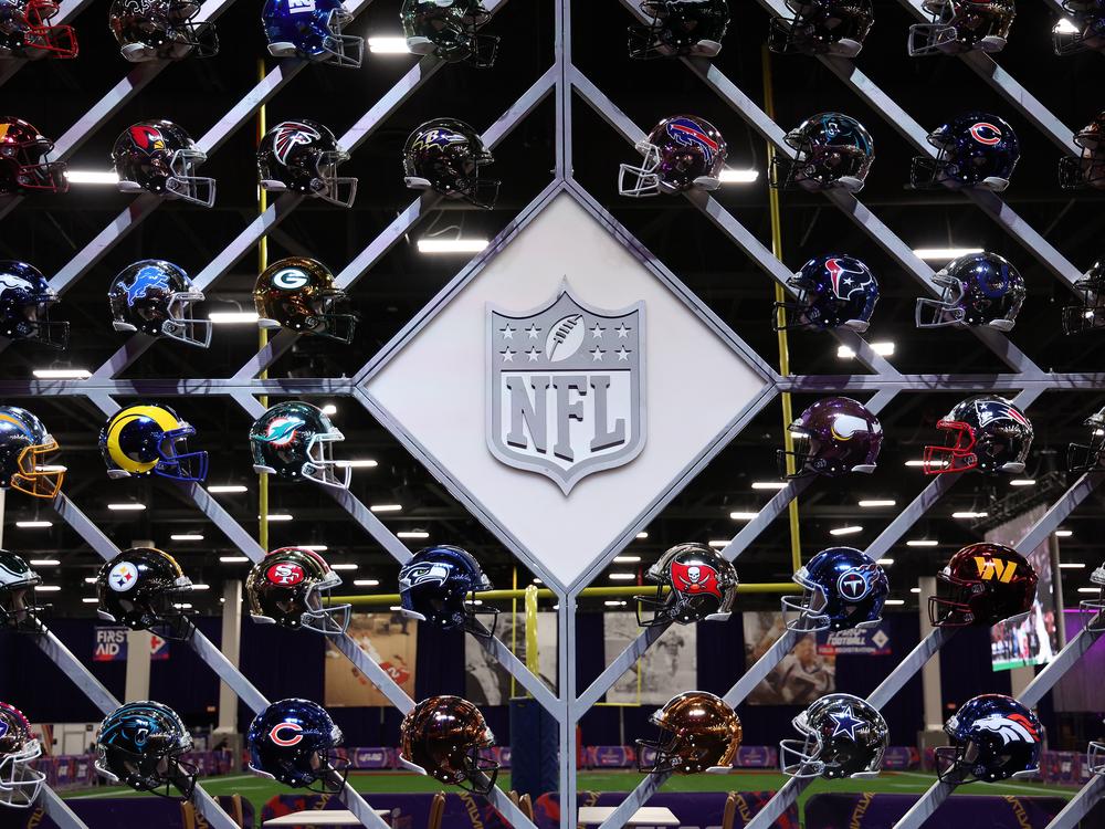 The NFL logo is surrounded by helmets of the 32 teams in the league. A new survey released Monday found that a third of former NFL players believe they have CTE, a degenerative brain disease linked to concussions.