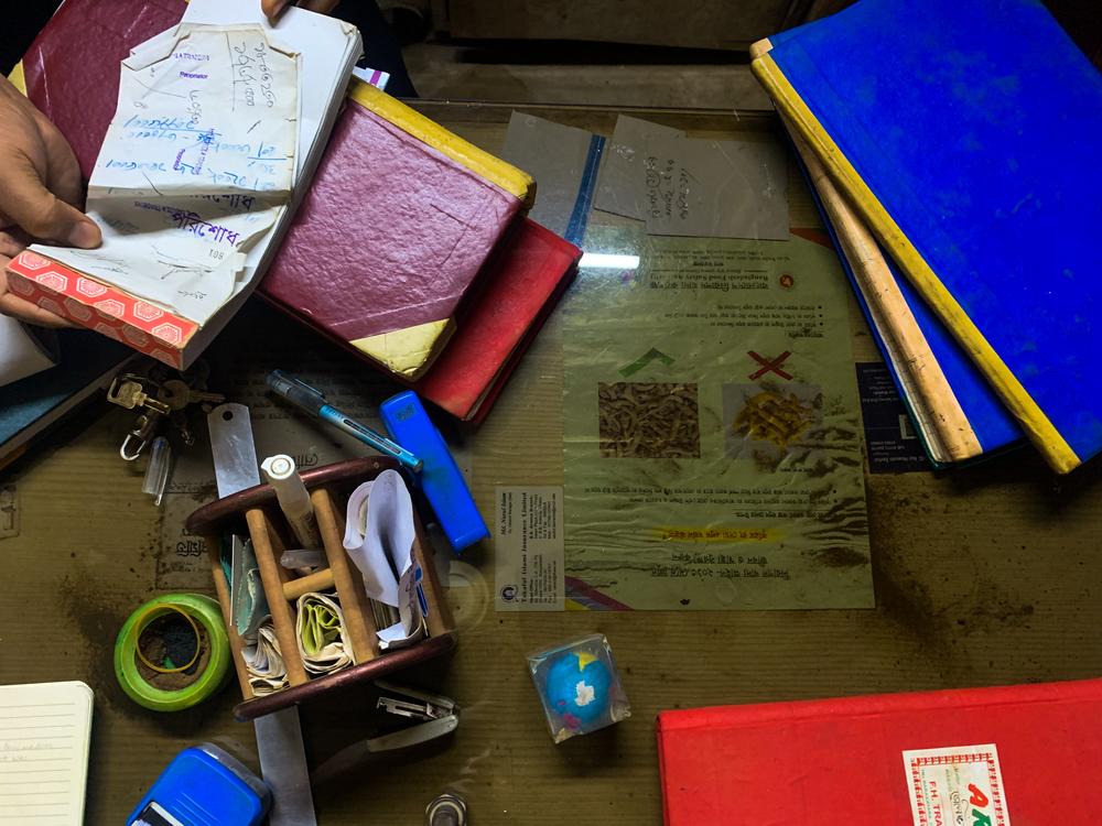 A 2019 flier from the Bangladesh Food Safety Authority is stored under glass on a vendor’s desk. A big red 
