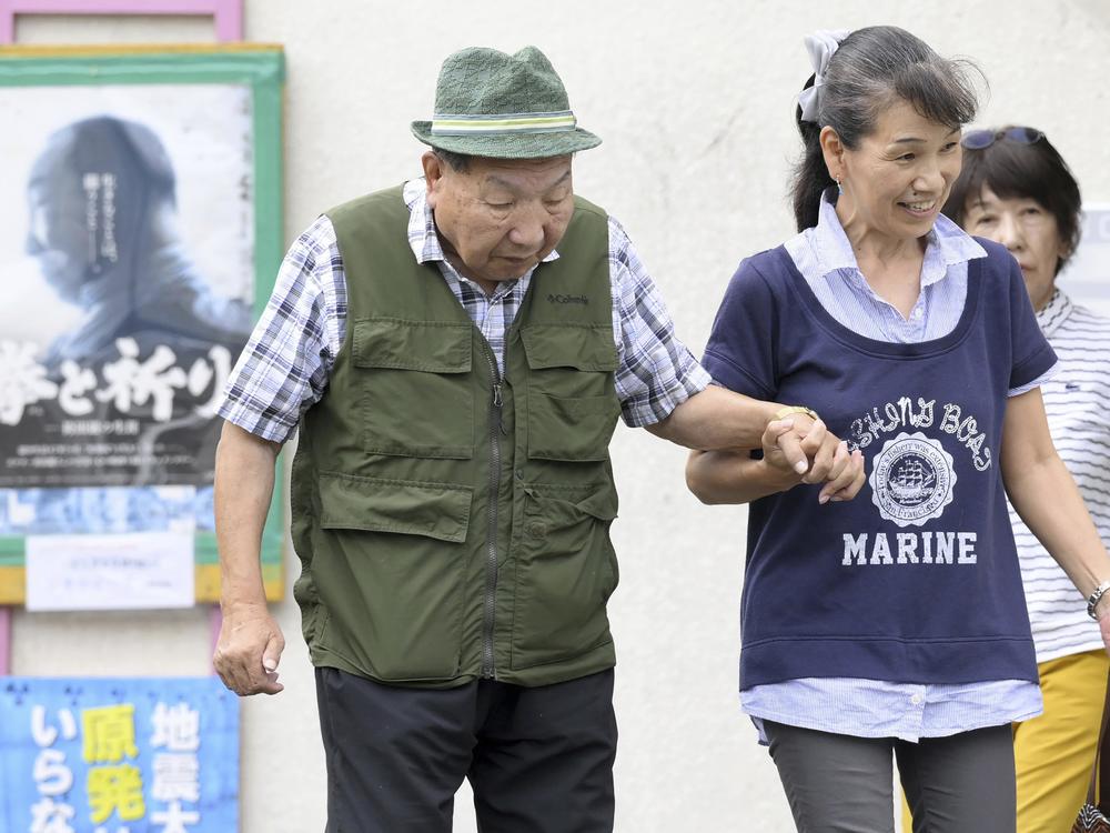 Iwao Hakamada, left, is helped by a supporter as he goes for a walk in Hamamatsu, Shizuoka prefecture, central Japan on Wednesday.