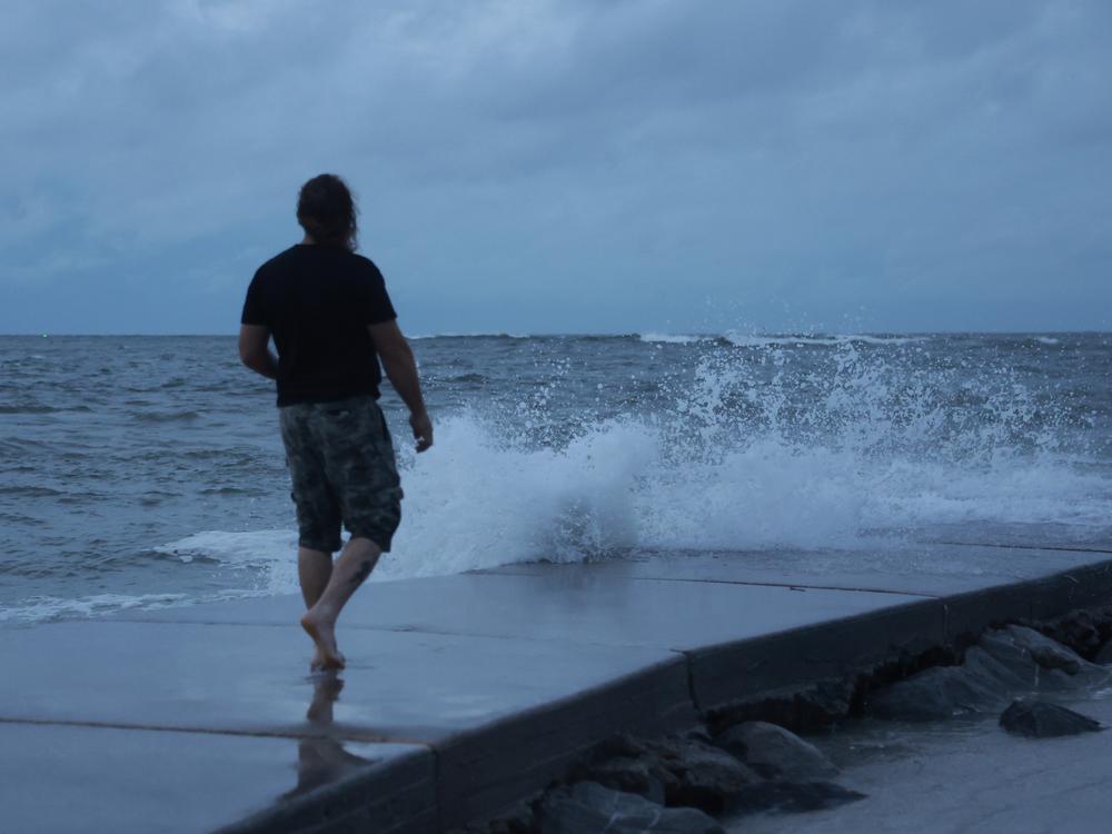 A man visits St. Pete Beach, Fla., as Hurricane Helene churns offshore early Thursday. Officials are urging residents in the path of the storm to heed evacuation orders and rush all preparations to completion. 