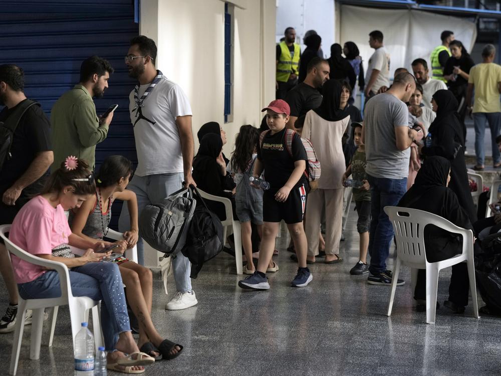 People fleeing the Israeli airstrikes in the south, arrive at a school turned into a shelter in Beirut on Monday.