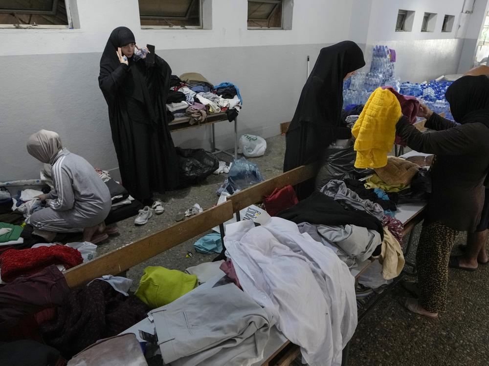 Volunteers distribute clothes to displaced women at a school in Beirut on Thursday.