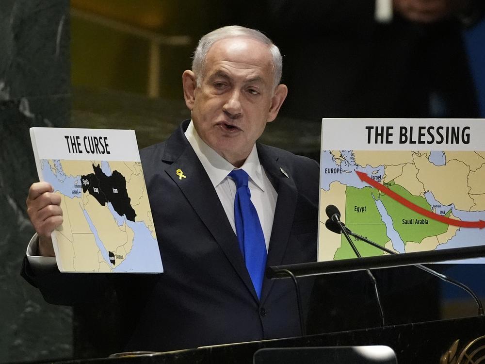 Prime Minister of Israel Benjamin Netanyahu hold signs as he addresses the 79th session of the United Nations General Assembly on Friday.