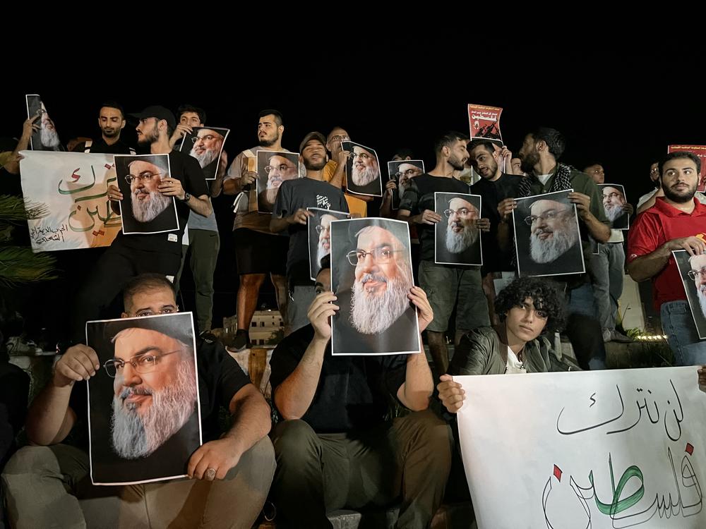 Demonstrators hold pictures of Hassan Nasrallah, late leader of the Lebanese group Hezbollah, during a protest vigil in the southern Lebanese city of Sidon on Saturday.