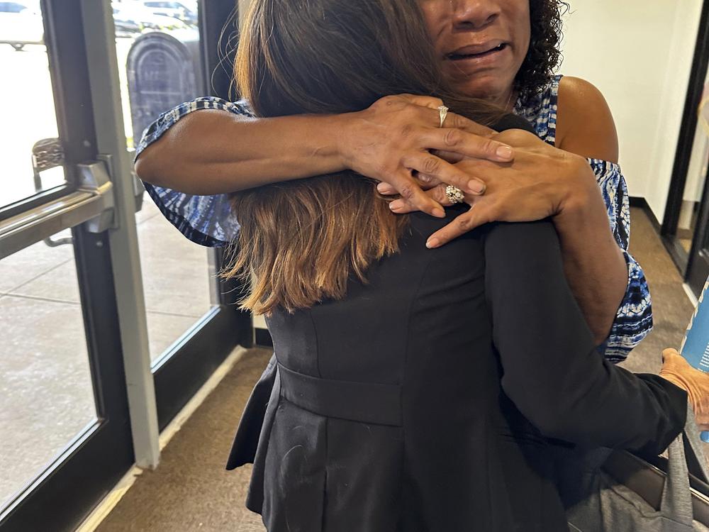 Augustina Sanders hugs Kim Ludwig, a paralegal in the Federal Public Defender's Office in Oklahoma City, on Wednesday, Aug. 7, 2024, after the Oklahoma Pardon and Parole Board voted 3-2 to recommend clemency for Sanders' brother, Emmanuel Littlejohn. (AP Photo/Sean Murphy)