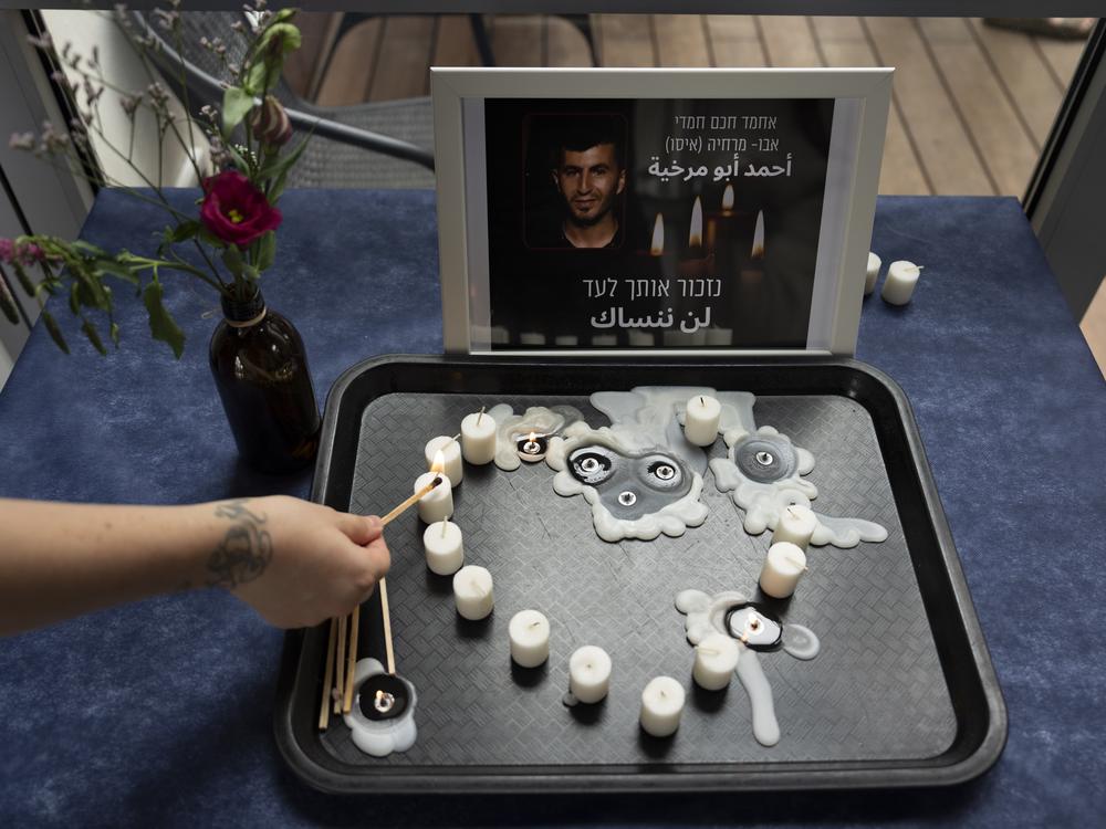 At an LGBTQ+ shelter in Tel Aviv, Israel, on Oct. 7, 2022, a volunteer lights a candle during a vigil for Ahmad Abu Markhiya, a 24-year-old Palestinian man who was found decapitated in the West Bank city of Hebron.