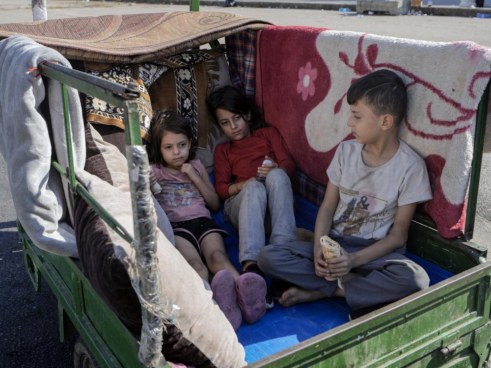 Children sit in a motorcycle cart in Beirut's Martyrs' square after fleeing the Israeli airstrikes in the southern suburbs of Dahiyeh, Sunday, Sept. 29, 2024.