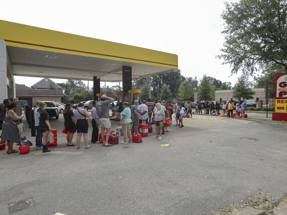 Residents wait in line with gas cans at a Gas Plus gas station in the aftermath of Hurricane Helene on Sunday in North Augusta, S.C.