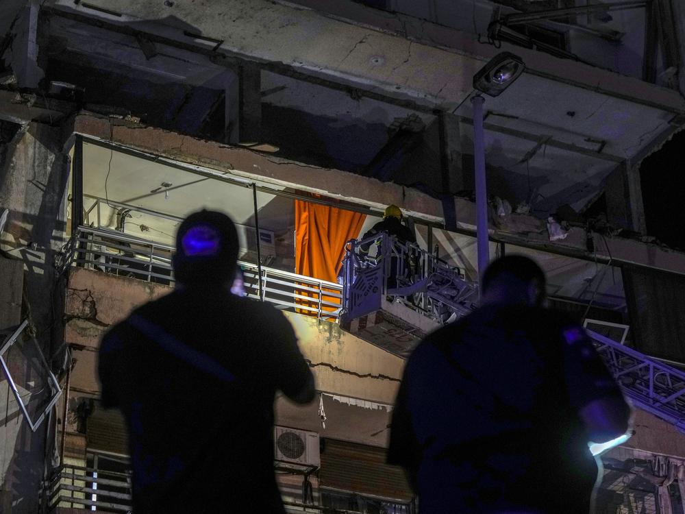 A fire engine ladder extends up a building that was hit in an apparent Israeli airstrike, in central Beirut early Monday, Sept. 30, 2024. 